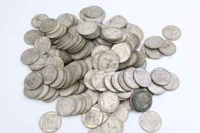 une pile de pièces d'argent sur une surface blanche
