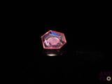 an image of a pink diamond sitting on top of a black surface