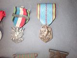 several medals are displayed on a gray surface with a red, white, blue, and green ribbon