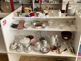 une cuisine où il y a beaucoup de vaisselle et de plats posés sur le plan de travail