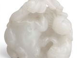 une sculpture blanche représentant un mouton, posée sur une surface blanche