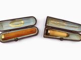deux stylos en bois dans un étui posé sur une surface blanche