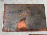 a piece of metal with rust on it sitting on the ground