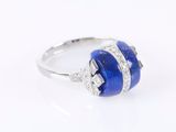 a close up of a ring with a blue stone and diamonds