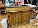 un chien debout sur le sol, à côté d'un comptoir en bois