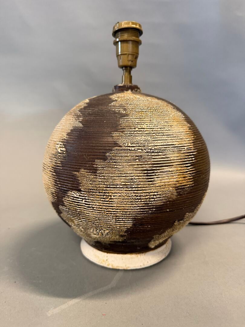 Louis DAGE (1885-1961) Lampe de table de forme boule en terre mêlée à décor de stries traités marron nuagé. Non signé...