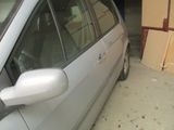 une voiture argentée garée dans un garage, à côté d'une pile de cartons