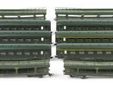 four green train cars sitting next to each other on a white surface
