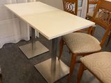 une table blanche et quatre chaises dans une pièce
