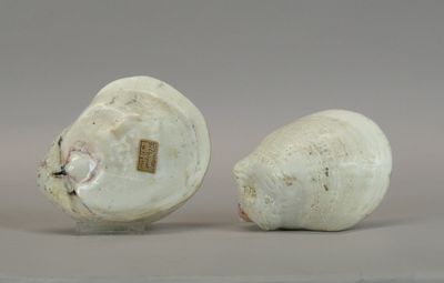 two white vases sitting next to each other on a table
