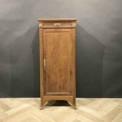 an old wooden cabinet with a door on top of a wooden floor