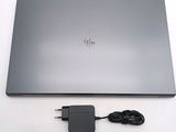 a laptop with a charger attached to it on a table