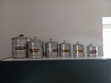 five metal containers sitting on top of a counter