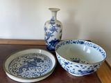 two bowls and a plate on a table with a lamp
