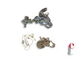 trois bijoux posés sur une surface blanche