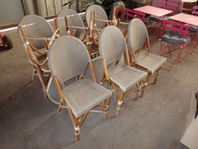 Plusieurs chaises sont alignées dans une pièce où l'on aperçoit, à l'arrière-plan, une table et des chaises.