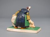 figurine of a woman in a blue dress with a green skirt on a green base