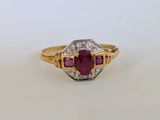 gros plan d'une bague en or avec un rubis et des diamants