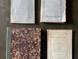 trois vieux livres posés sur une table l'un à côté de l'autre