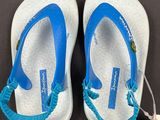 pair of white and blue flip flops with a tag on them