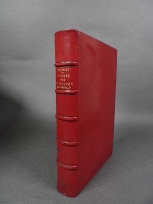 un livre rouge à quatre dos sur fond gris