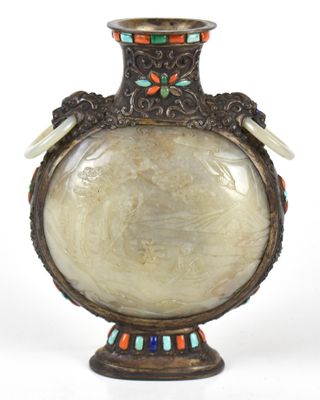 un vase orné d'un oiseau et décoré de perles