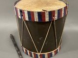 an old drum with a wooden handle and a wooden stick