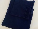 navy blue sweater folded on top of a white table