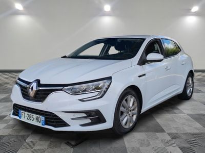 une voiture blanche garée dans une pièce au sol en damier