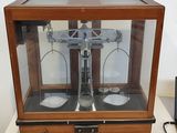 a small scale in a glass case on a table