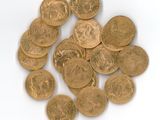 a pile of gold coins sitting on a white surface