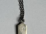 a close up of a metal object on a chain on a table