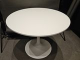 a white table with a black chair next to it