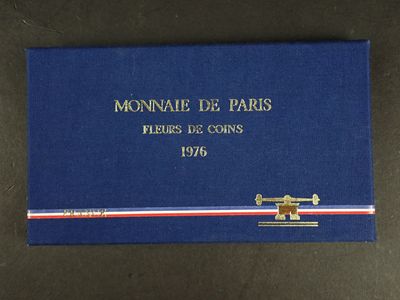 un gros plan sur une boîte bleue sur laquelle est posée une médaille d'or