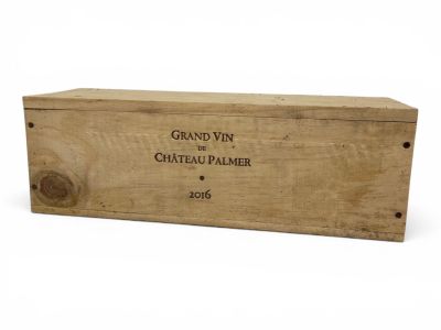 an old wooden box with a label on it sitting on a white surface