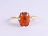 an image of a ring with an orange stone in it