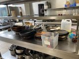 many pots and pans sitting on a metal shelf