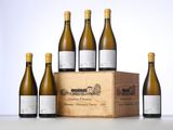 six bottles of white wine in a wooden box on a table