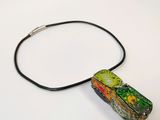 a picture of a necklace with a piece of art on it