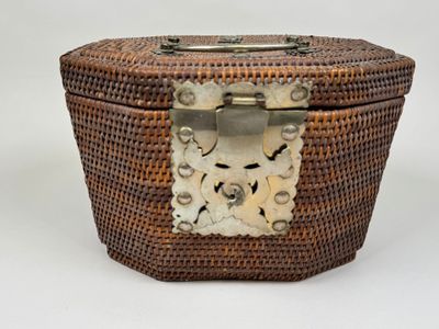 une boîte en osier avec une poignée en métal sur fond blanc