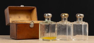 trois flacons de parfum posés à côté d'une boîte en bois