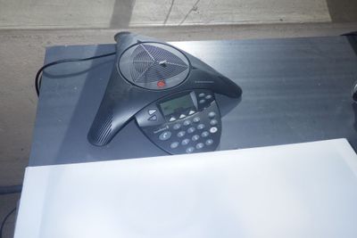 un téléphone posé sur une table à côté d'une feuille de papier