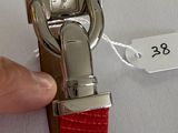 a person that is holding a red watch in their hand