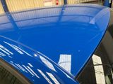 a close up of a car ' s roof with a blue paint job