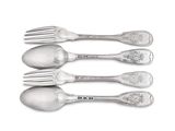 four silver spoons and a fork are lined up on a white surface