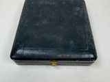 an old black case sitting on top of a white table