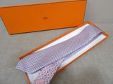 purple and white patterned tie in a box with a pink tie