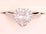 an engagement ring with a heart shaped diamond surrounded by diamonds