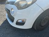a small white car parked on the side of the road