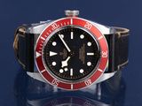 a red and black watch on a black surface